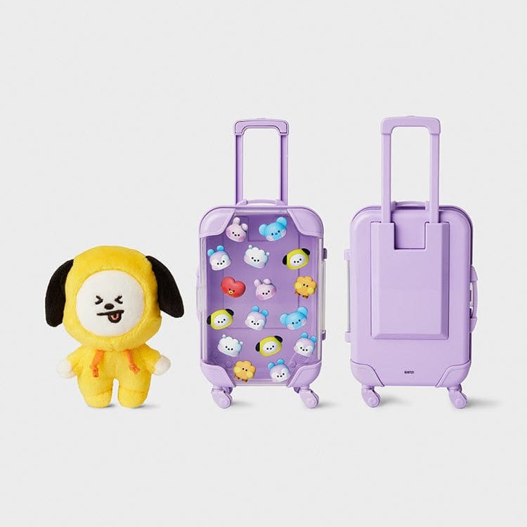 Stuffed yellow puppy plushie and two small purple luggage suitcases.
