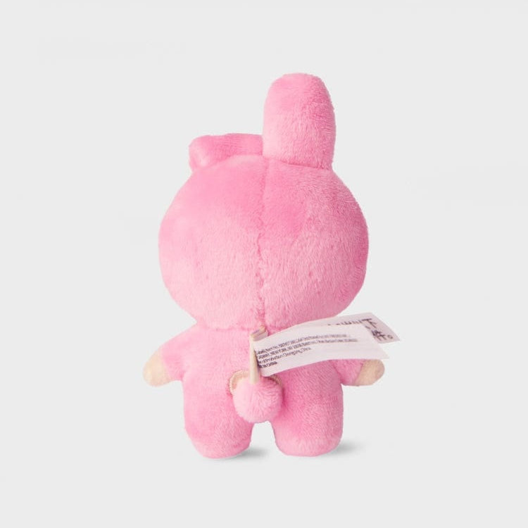 Back view of a pink, fuzzy, stuffed rabbit toy with a white tag.