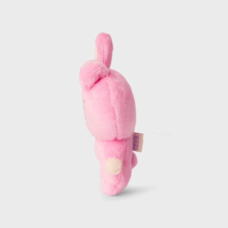 Side view of a pink, plush bunny toy with one ear sticking up.