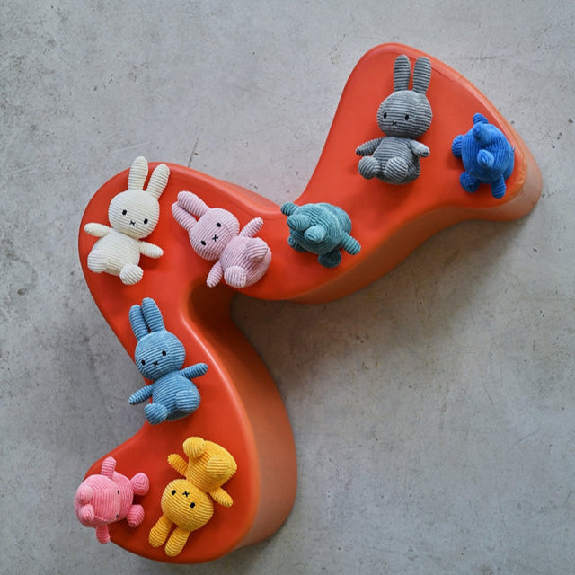 Assorted plush bunnies and turtles arranged on an orange wave-shaped platform.
