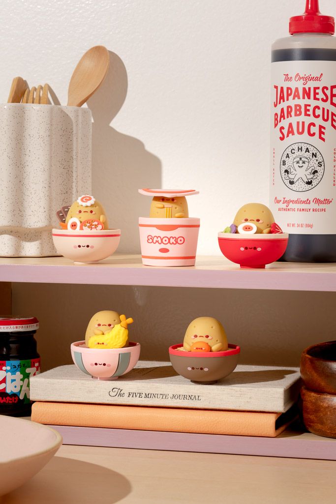 Collection of adorable potato-shaped figurines in bowls, displayed on shelves with kitchen items.