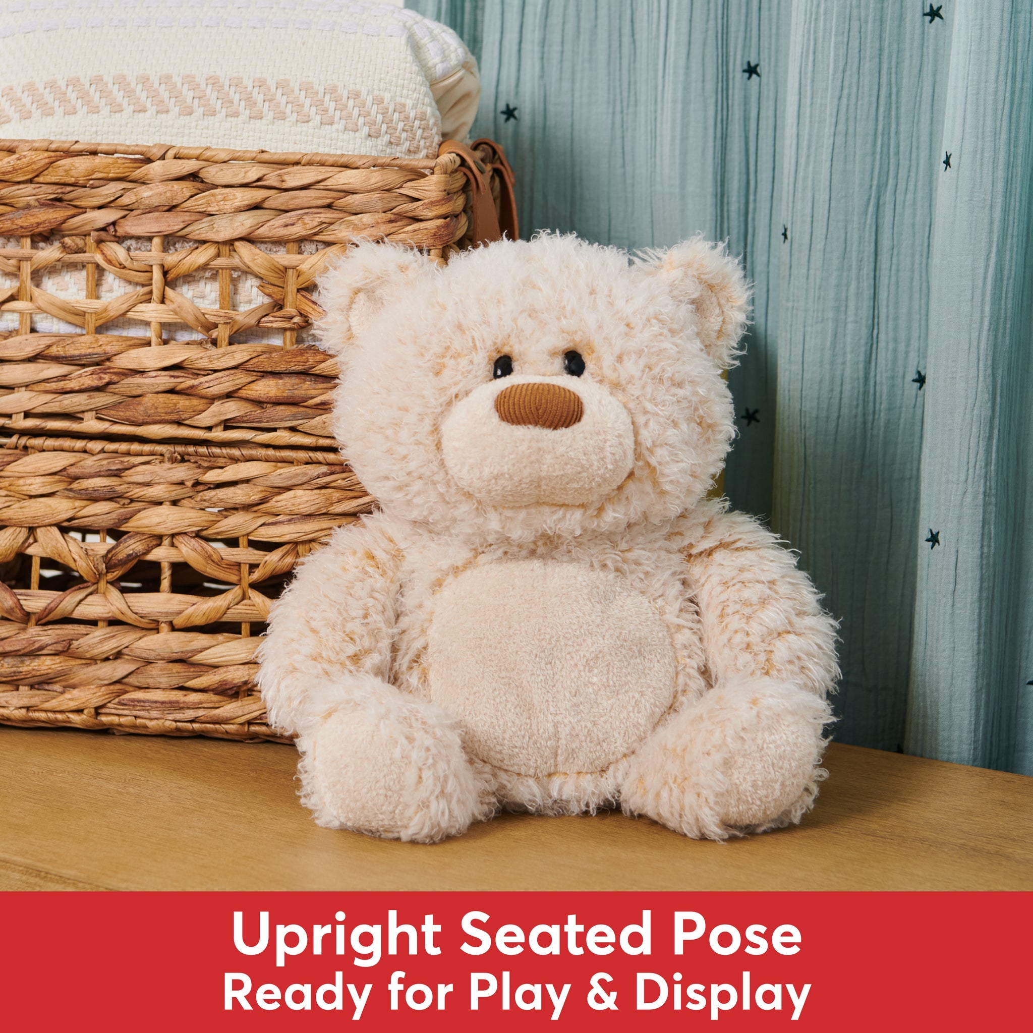 Stuffed teddy bear sitting next to a woven basket and a sheer, star-printed curtain.