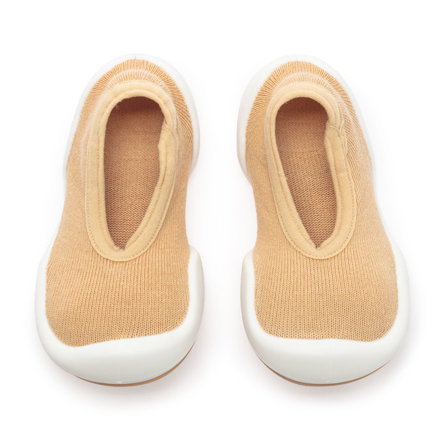 A pair of beige toddler shoes.