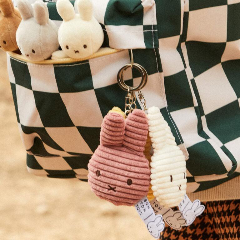 Checkerboard tote bag with plush bunny charms.