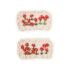 Two knitted rectangles with embroidered red and yellow flowers.