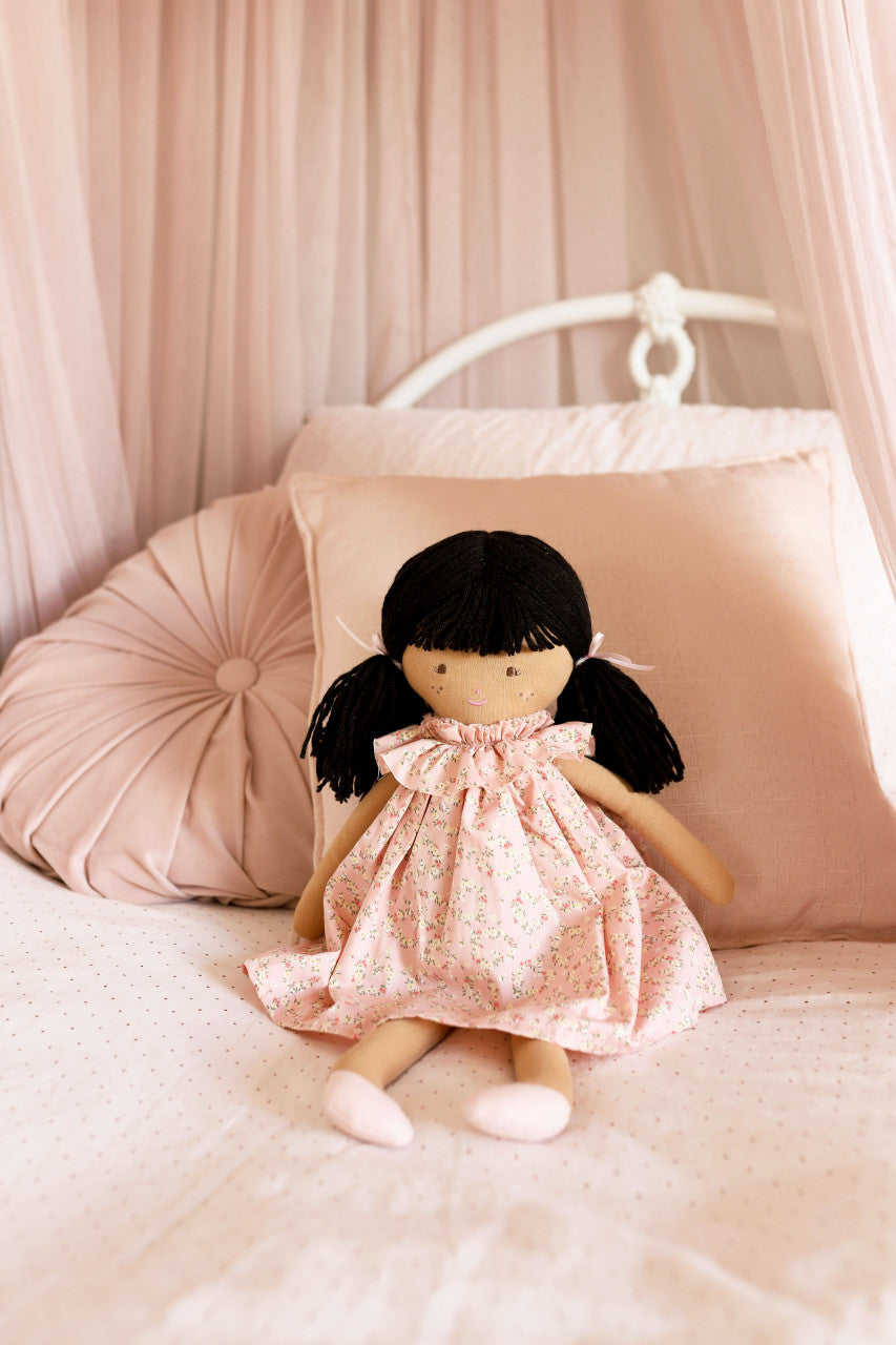 Ragdoll in a pink floral dress with black hair.