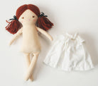 Cloth doll with auburn yarn hair, black ribbon ties, and a white frilly skirt.