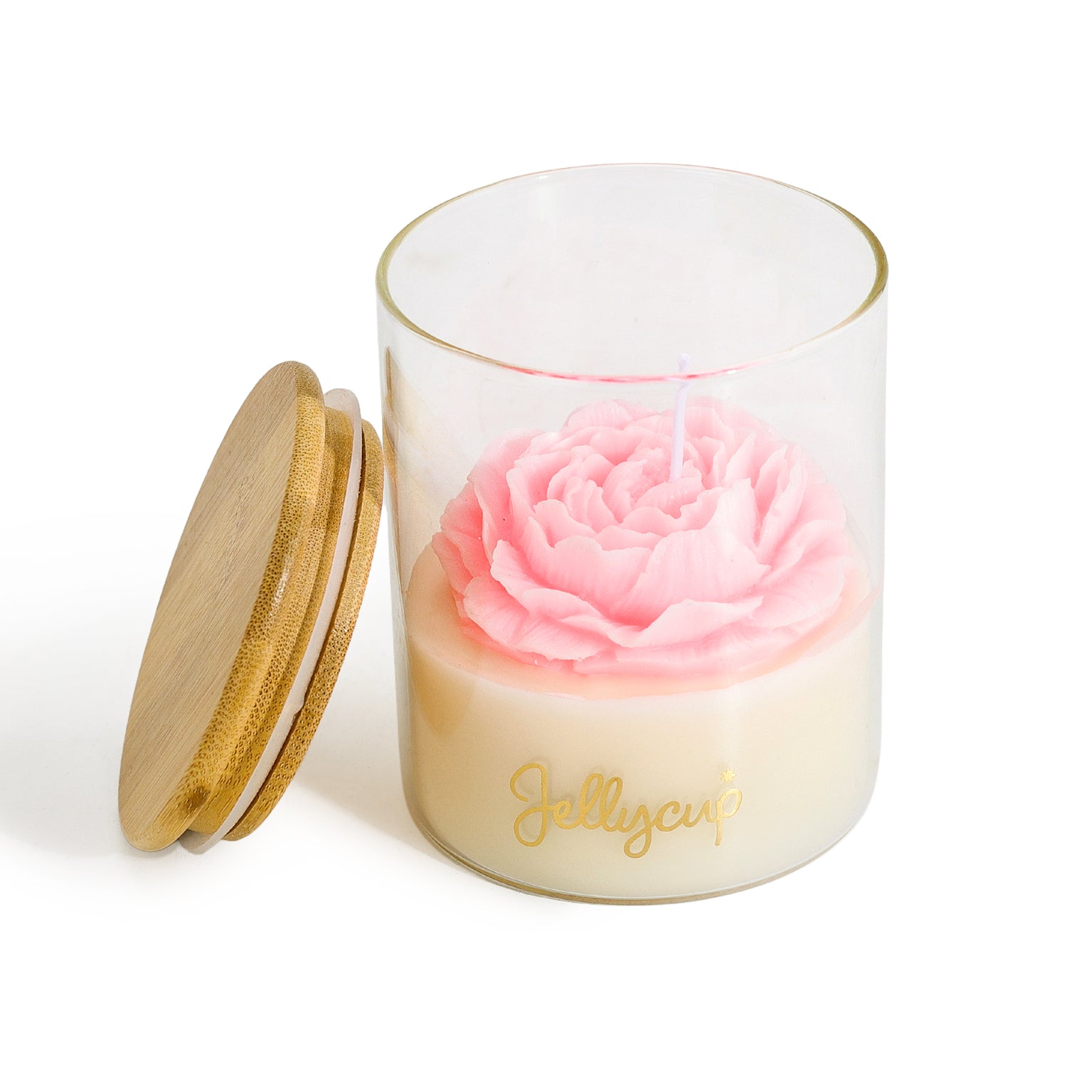 A clear glass jar candle with a cream-colored wax base, a pink rose-shaped wax top, and gold foil script reading 'Jellycup' on the front. A light wood lid with a gold rim rests beside the jar on a clean white background.