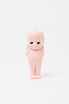 Small figurine of a baby with a bald head on a white background
