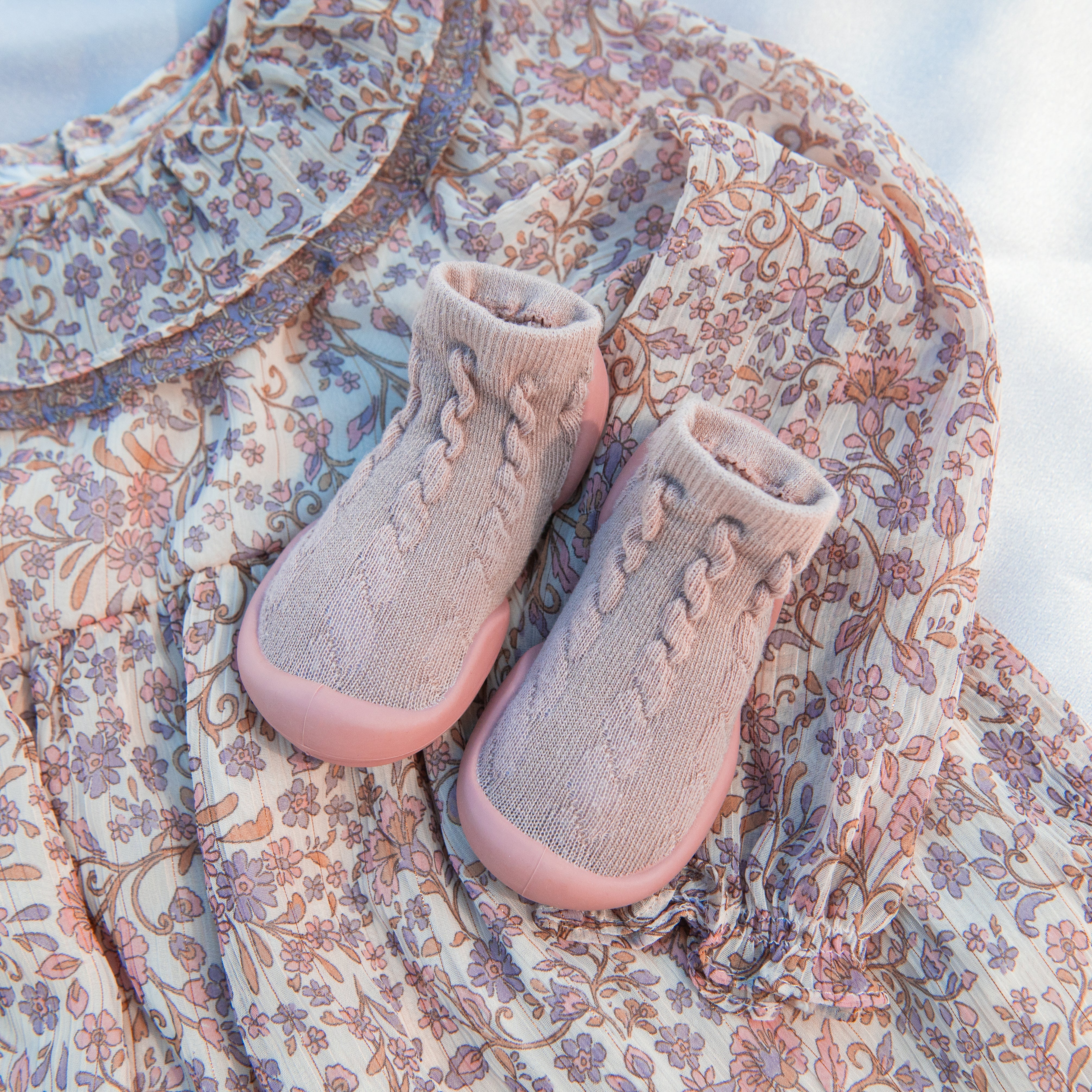 Floral print baby dress and a pair of pink sock-shoes.