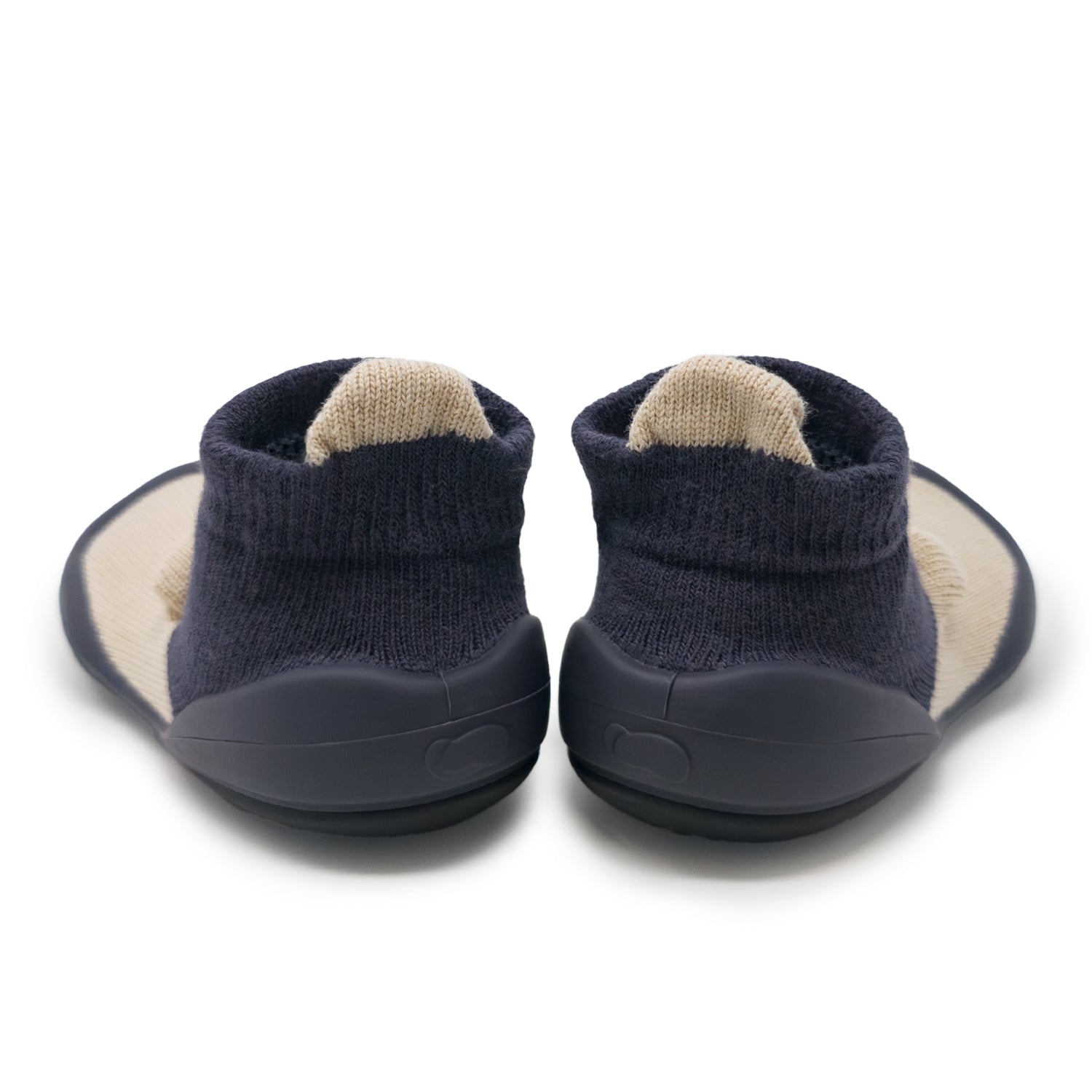 Pair of navy baby shoes with beige soles on a white background