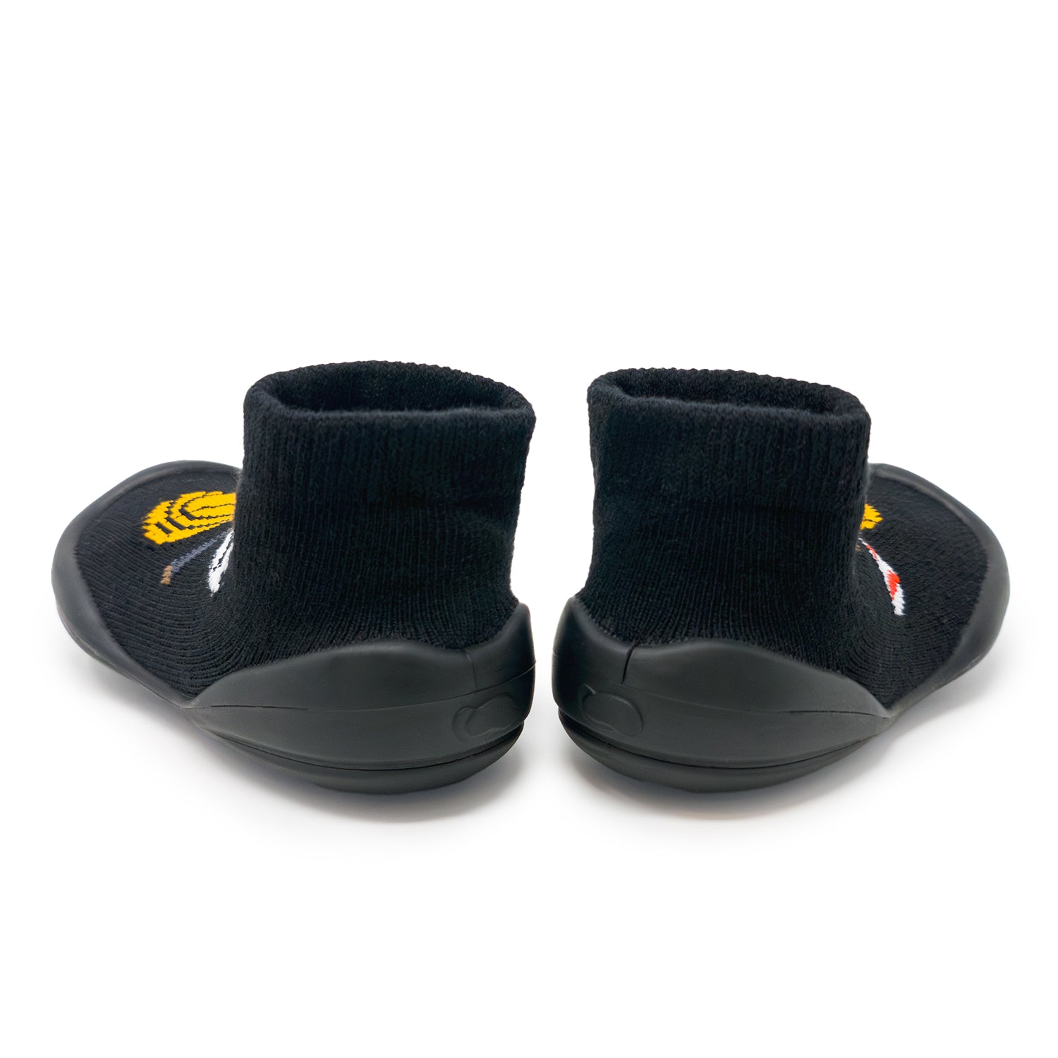Pair of black baby booties with yellow and white designs on a white background