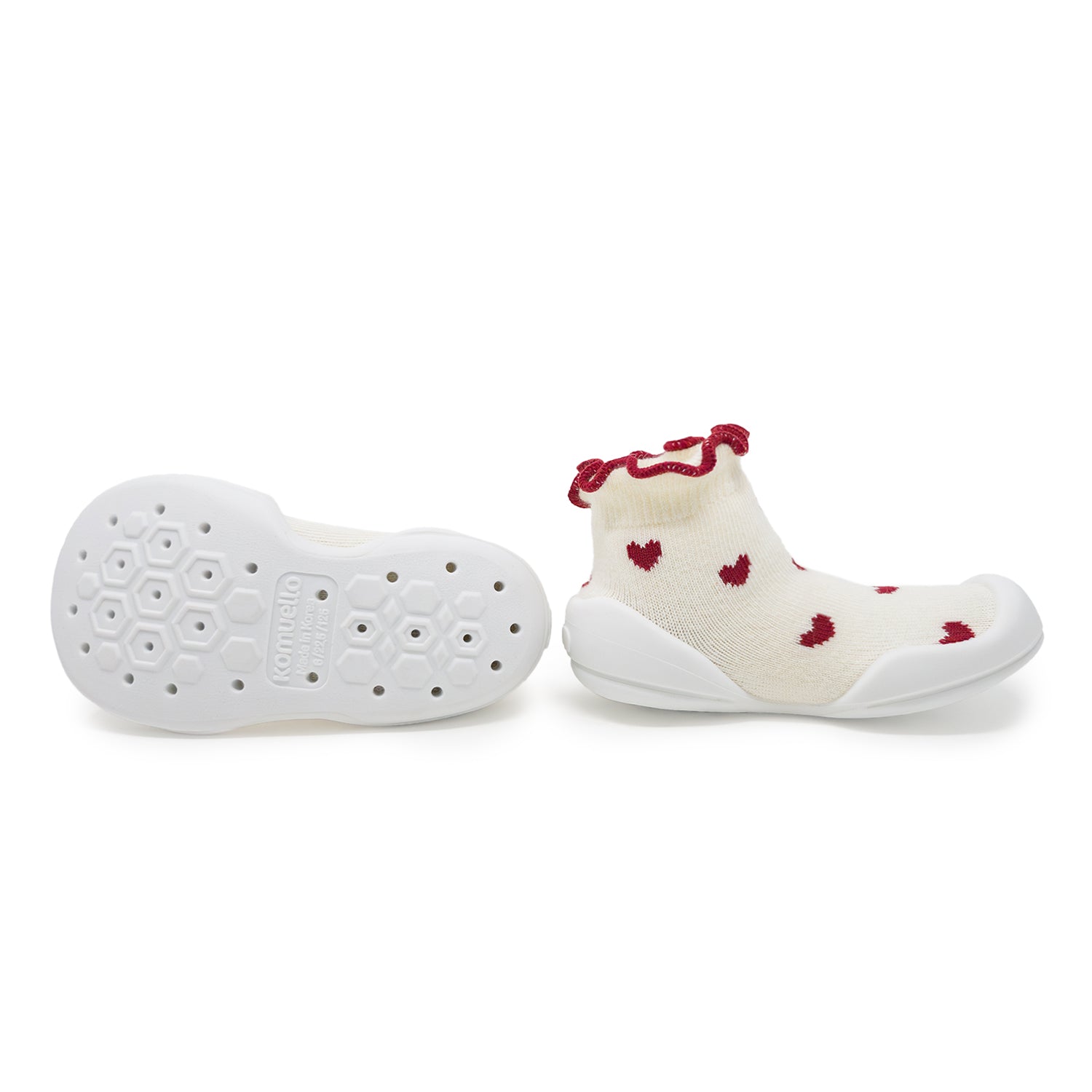 White baby shoes with red heart patterns on a white background