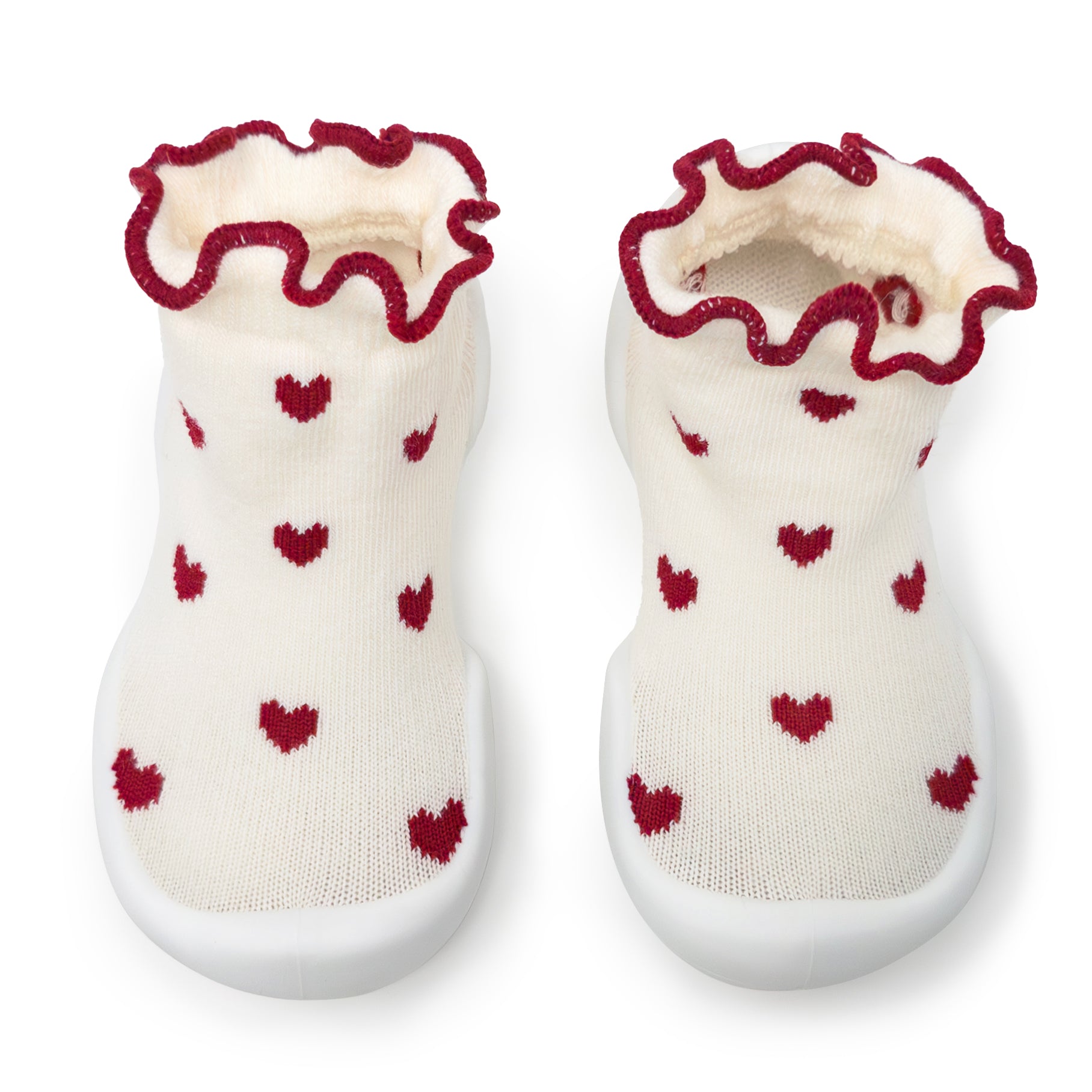 Pair of baby shoes with red heart patterns on a white background