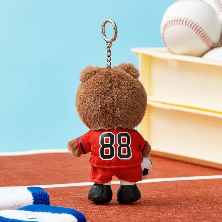 Brown teddy bear keychain in red soccer uniform with the number 88 on its back.