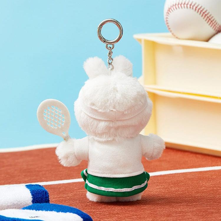 Rear view of a white, plush rabbit keychain wearing a tennis outfit, including a white top, green skirt, and white visor, holding a white tennis racket.