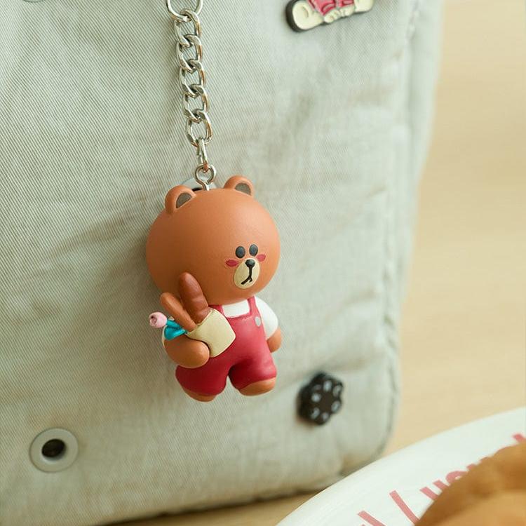 Brown bear keychain wearing red overalls.
