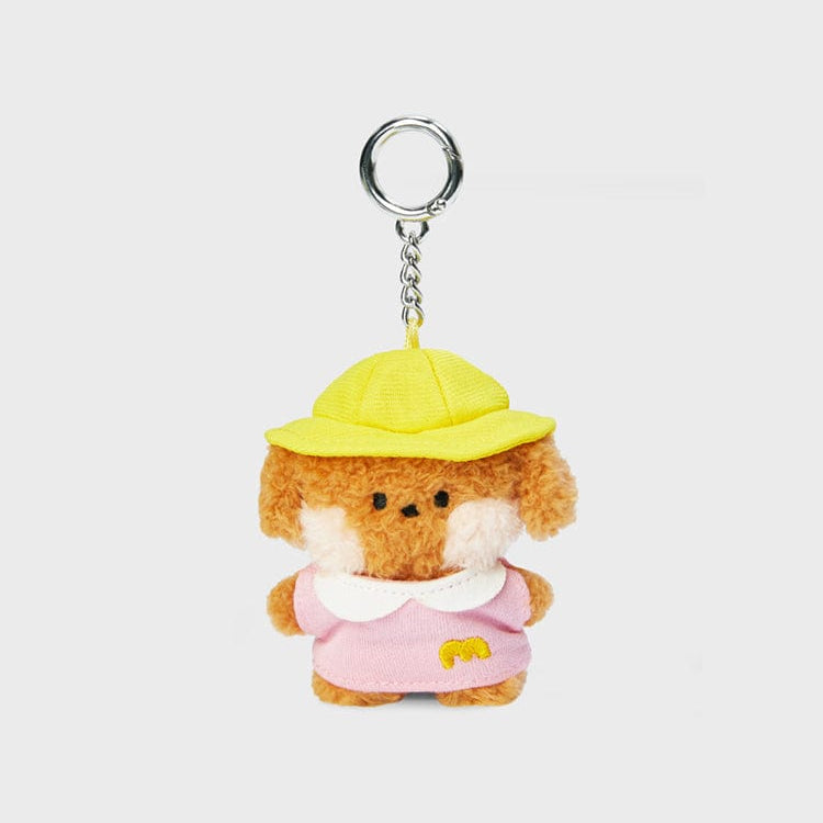 Brown and white plush dog keychain with yellow hat and pink dress.