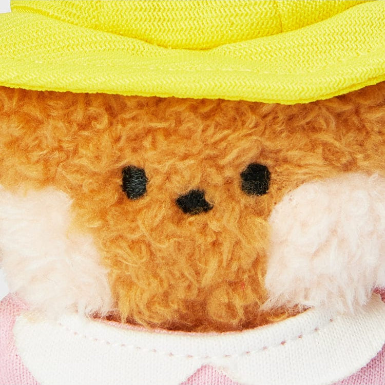 Stuffed animal with a yellow hat and pink shirt.