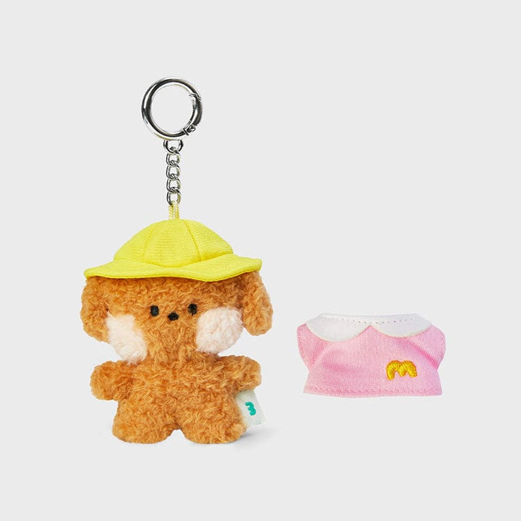 Stuffed brown dog keychain with a yellow hat and a pink dress with a white collar.