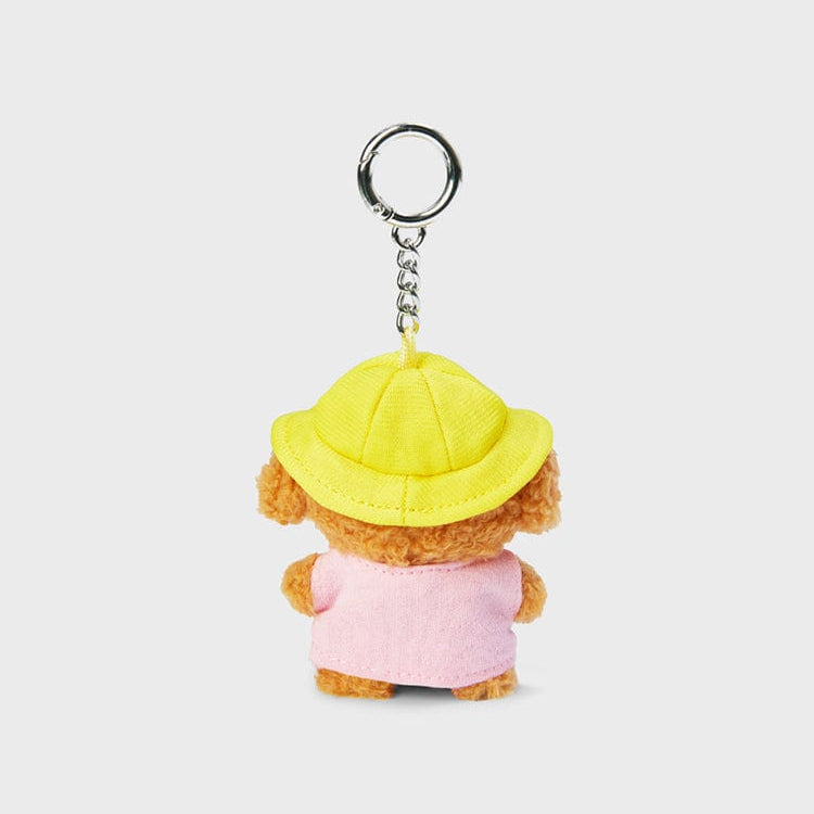 Back view of a teddy bear keychain wearing a yellow hat and pink shirt.