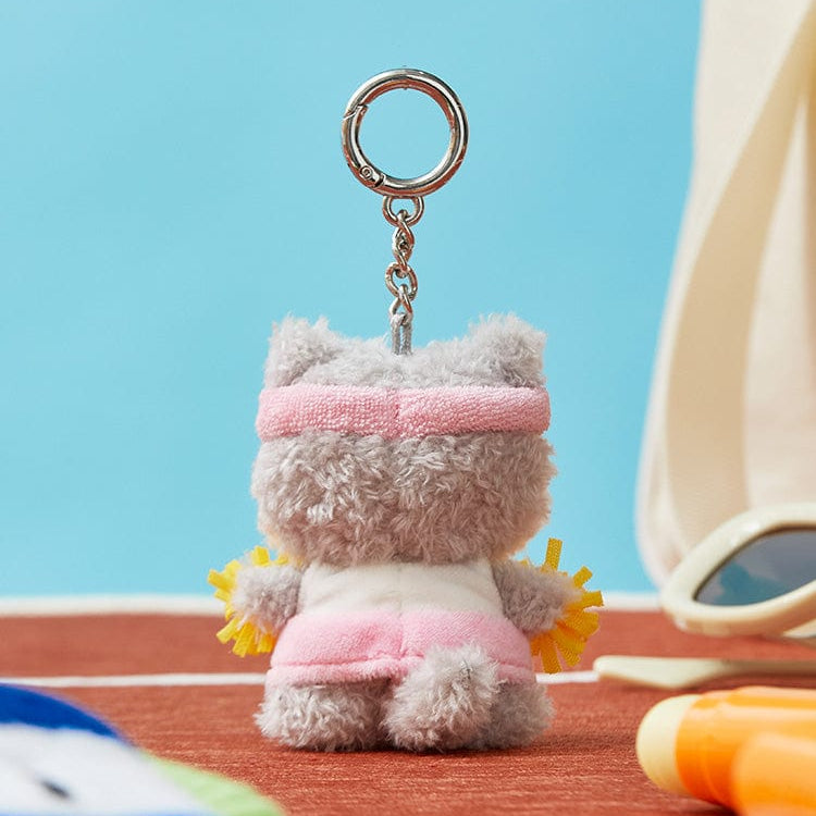 Back view of a gray, fuzzy, cat-shaped keychain wearing a pink headband, a white shirt, pink shorts, and holding yellow pom-poms.