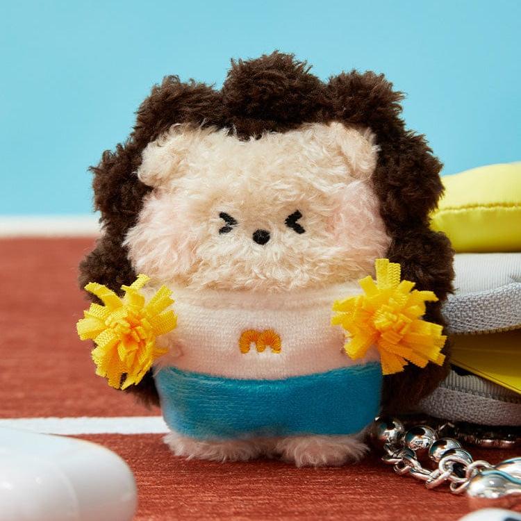Stuffed hedgehog cheerleader holding yellow pom-poms.