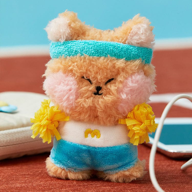 Stuffed animal wearing a blue headband and blue shorts, holding yellow pom-poms.