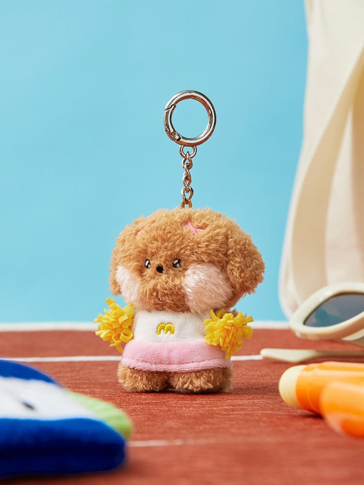 Stuffed dog keychain with cheerleader outfit on a running track.