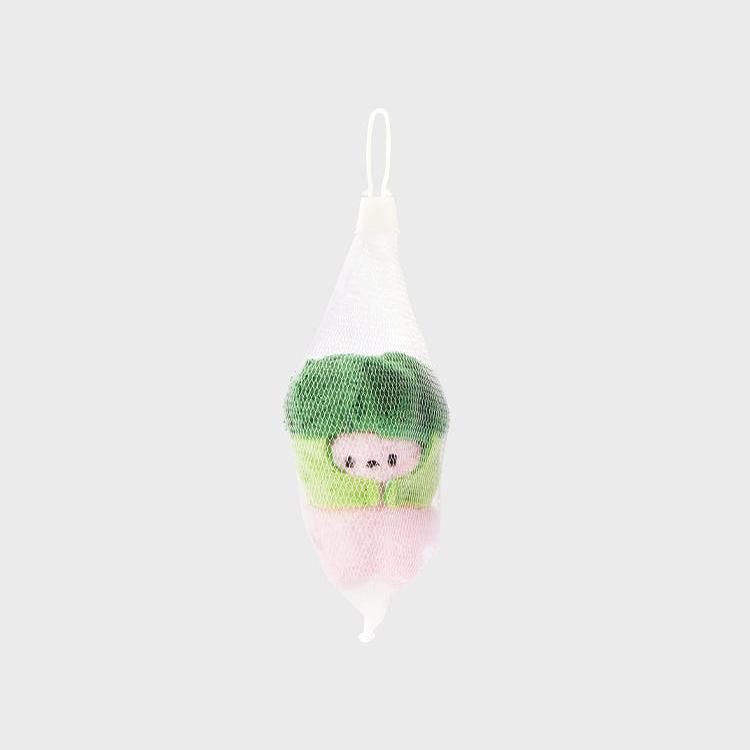 Green and pink plush toy in a white mesh bag.