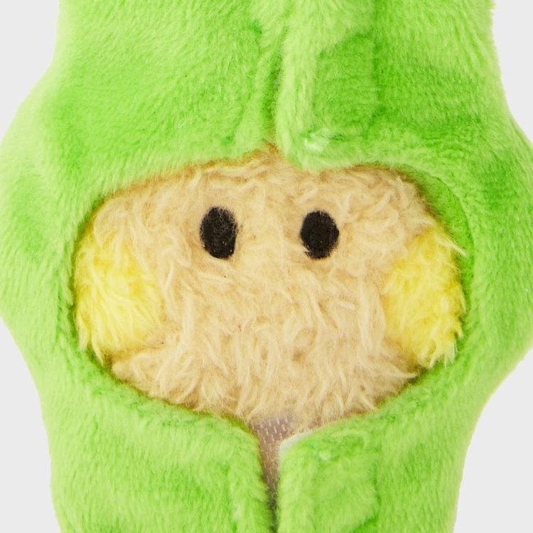 Close-up of a plush toy with a furry, light-yellow face, black eyes, and a green hooded outfit.