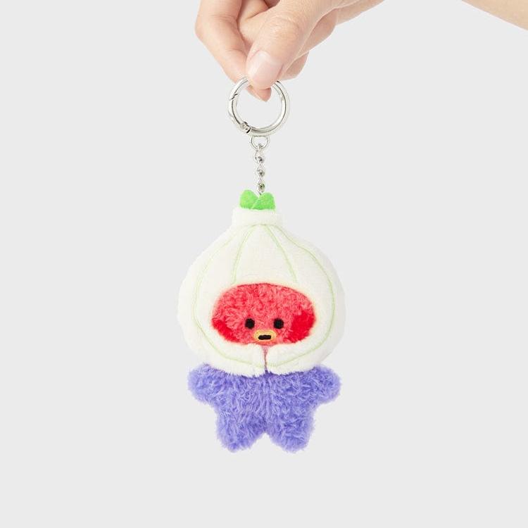 Plush keychain of a red and purple character dressed as an onion, held by a hand.