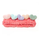 Pink plush headband with soft pastel hearts.