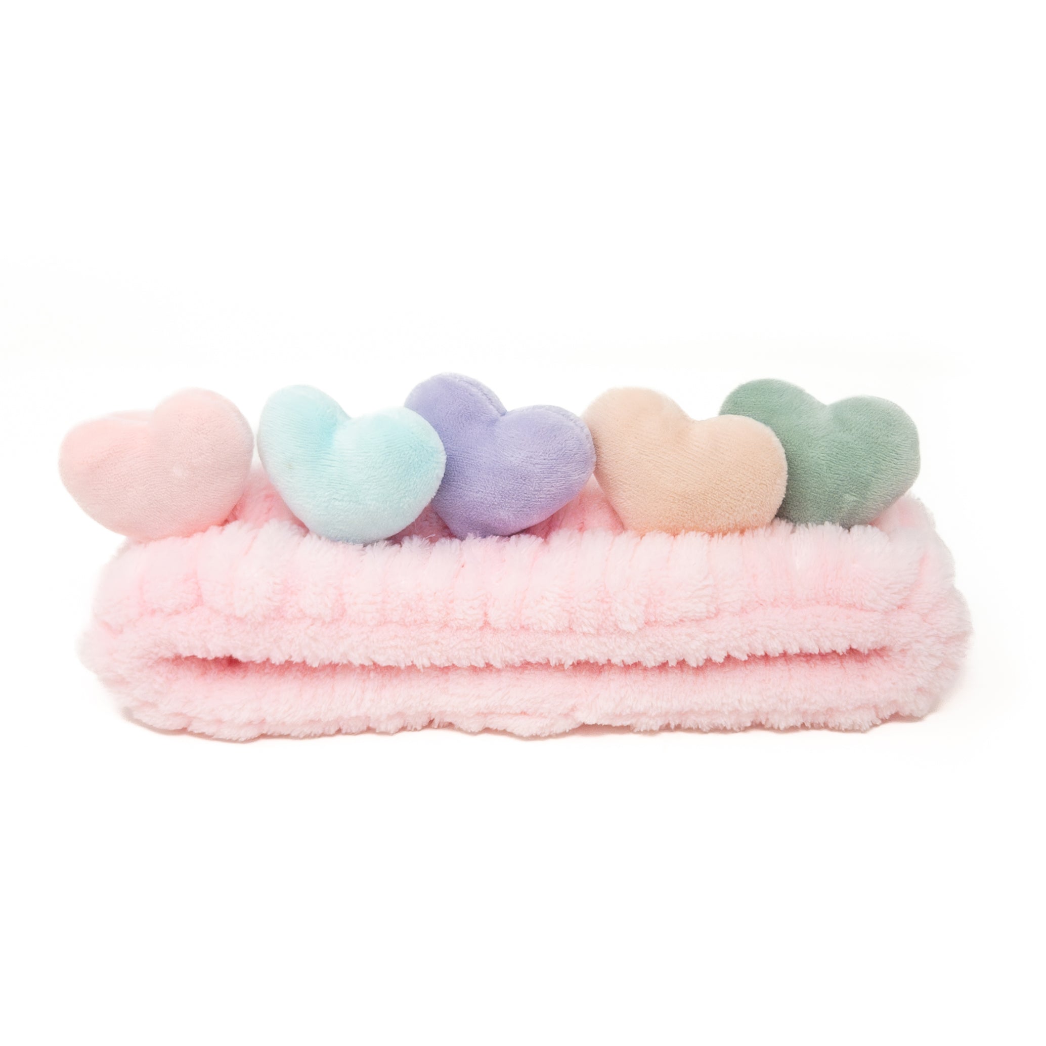 Pink plush headband with five pastel heart accents.