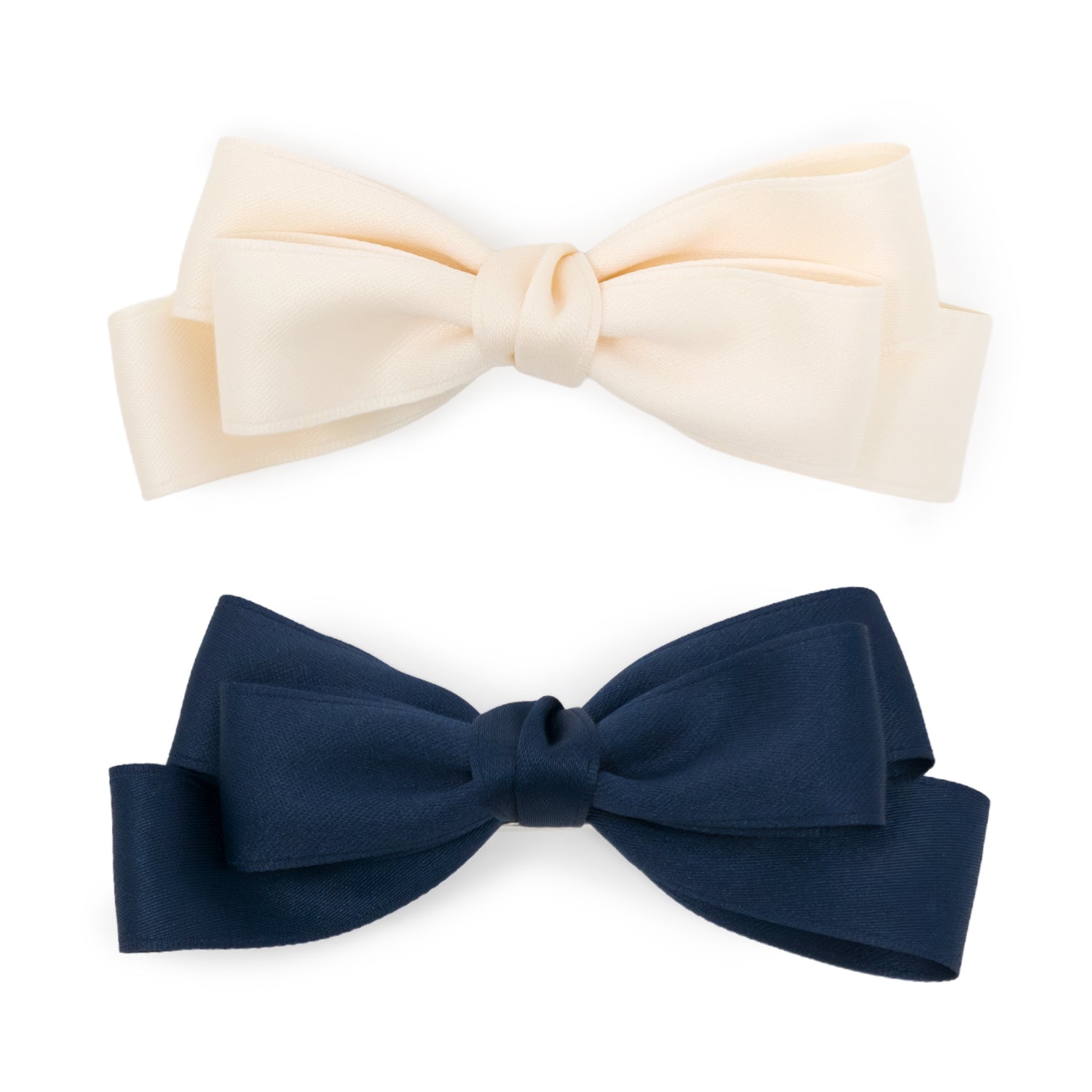 A set of two large double bow clips, one cream and one navy blue, made from textured fabric, displayed on a white background.