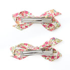 Two floral print bow hair clips with metal clips on a white background.