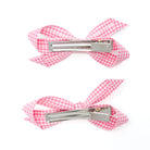 Two pink and white gingham hair clips, bow-shaped with silver alligator clips.