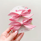 Two pink and white gingham bows on a product card.