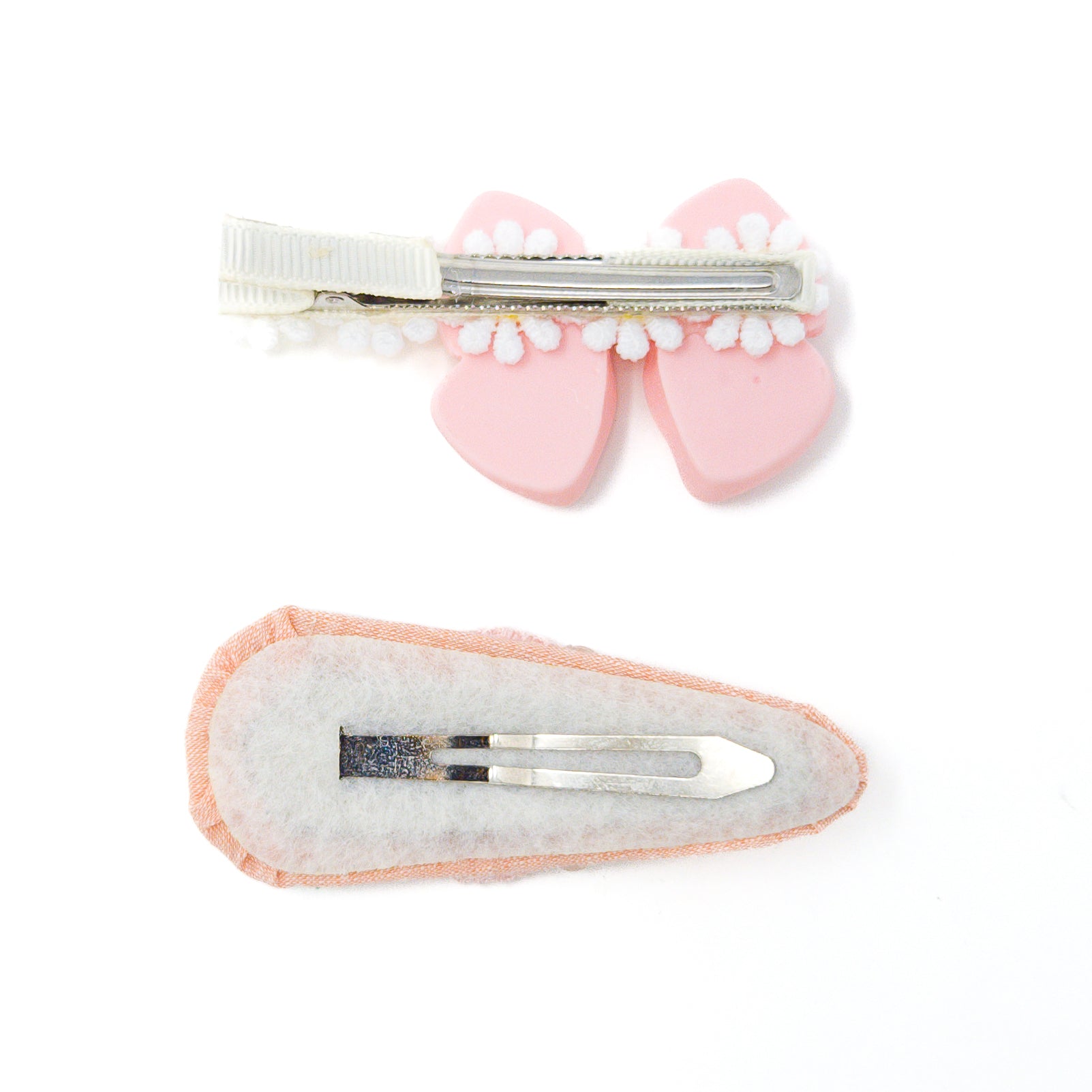 Two hair clips, one pink bow with a white beaded trim and the other a pink and white oval.