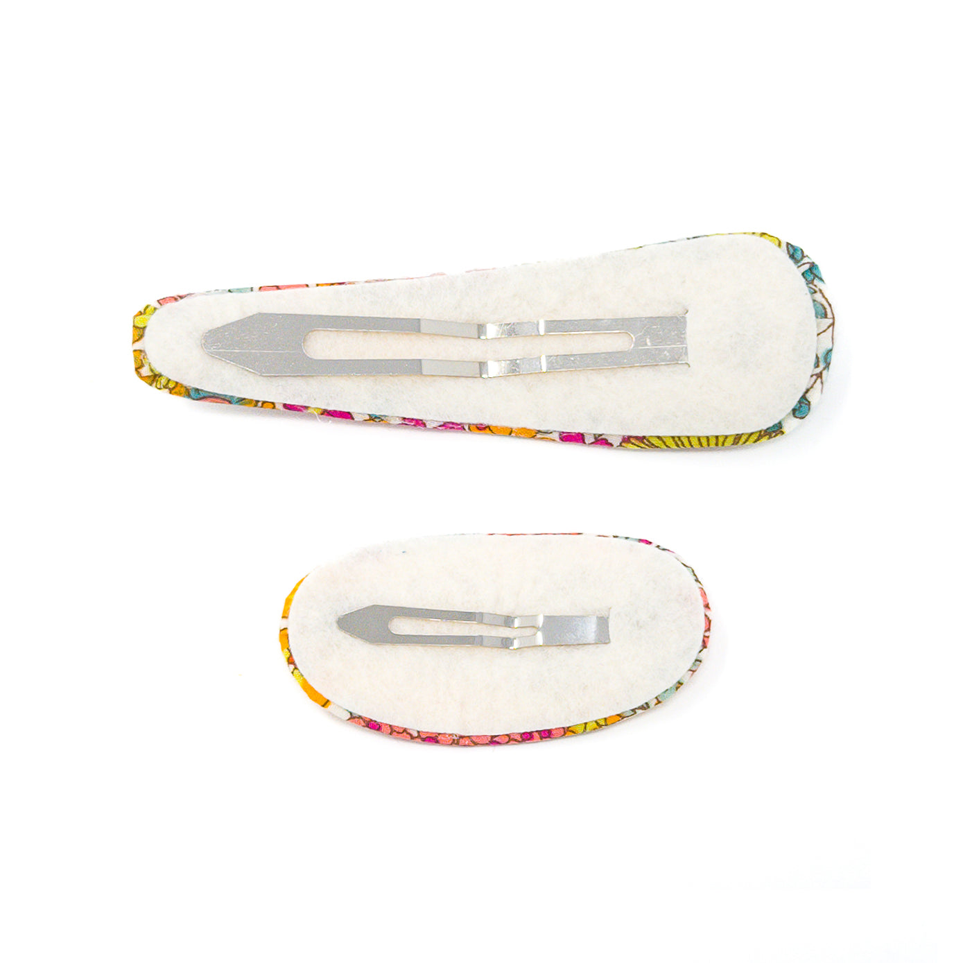 Two floral fabric-covered hair clips, showing the plain, felted underside with metal clasps.