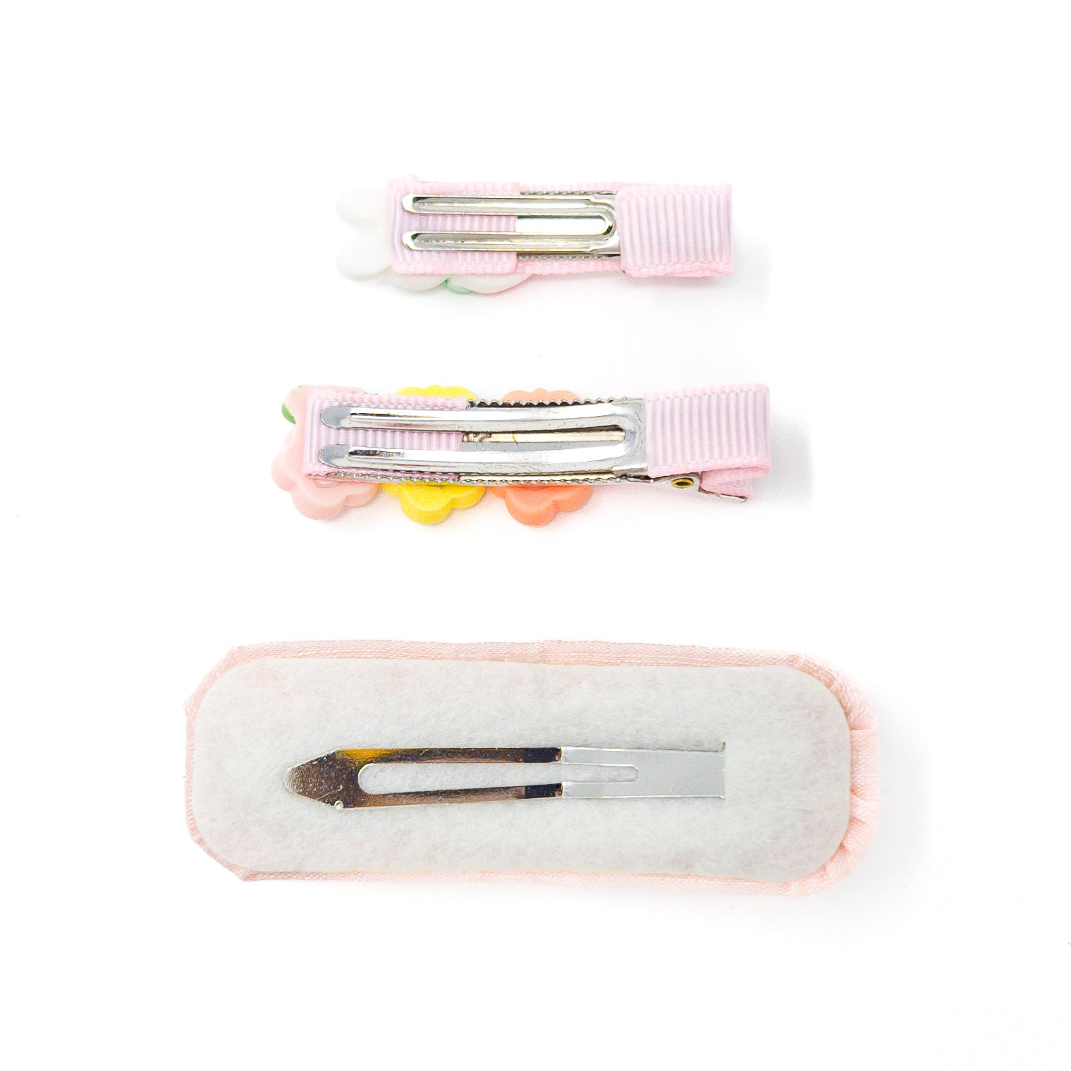 Three pink hair clips on a white background.