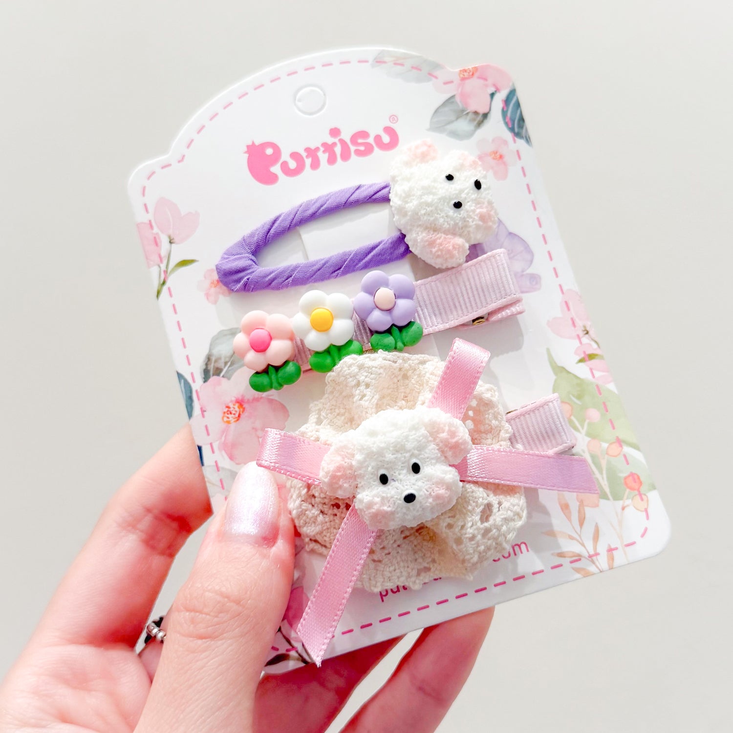 Three hair clips with floral and animal decorations. The clips are mounted on a decorative card with the brand name "Porriso".