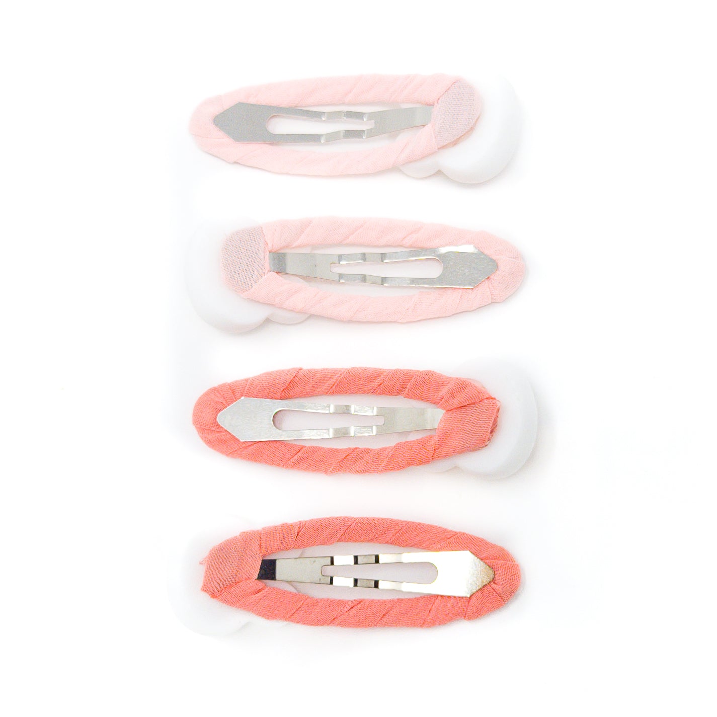 Four oval hair clips with pastel fabric and metal clasps.