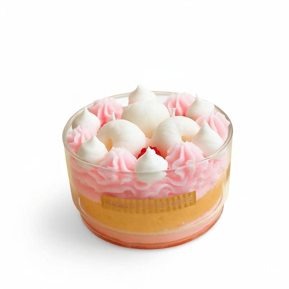 Cupcake in a glass with pink frosting and white meringues on a white background