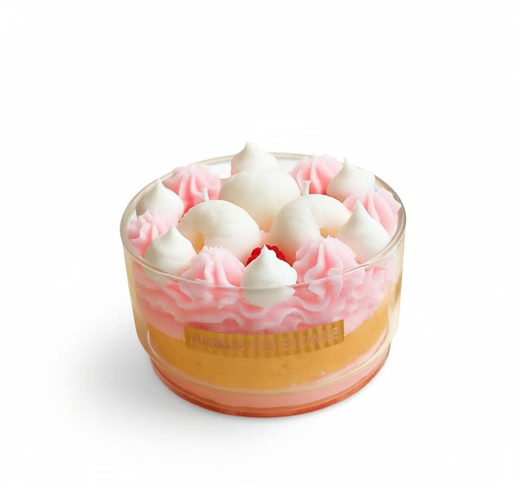 Cupcake in a glass with pink frosting and white meringues on a white background