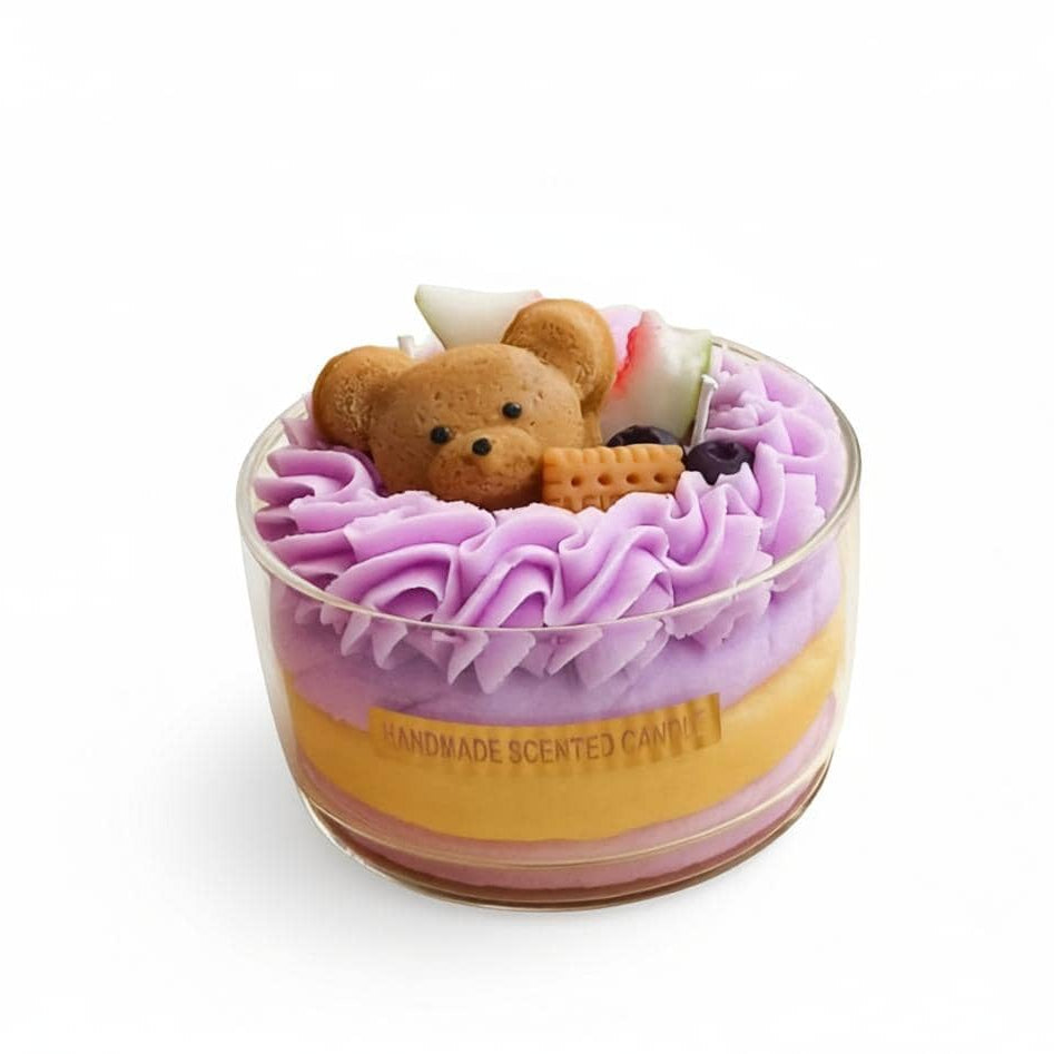 Handmade scented candle with a teddy bear design on top, featuring purple and yellow layers.