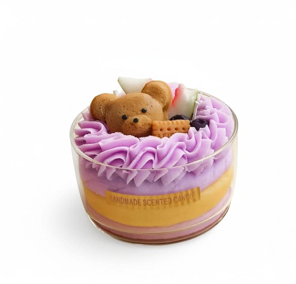 Handmade scented candle with a teddy bear design on top, featuring purple and yellow layers.