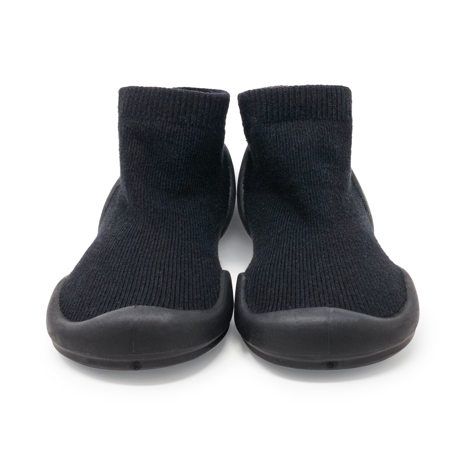 A pair of black sock shoes with rubber soles.