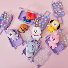 Plush toys in small, light purple suitcase toys on a pink surface.