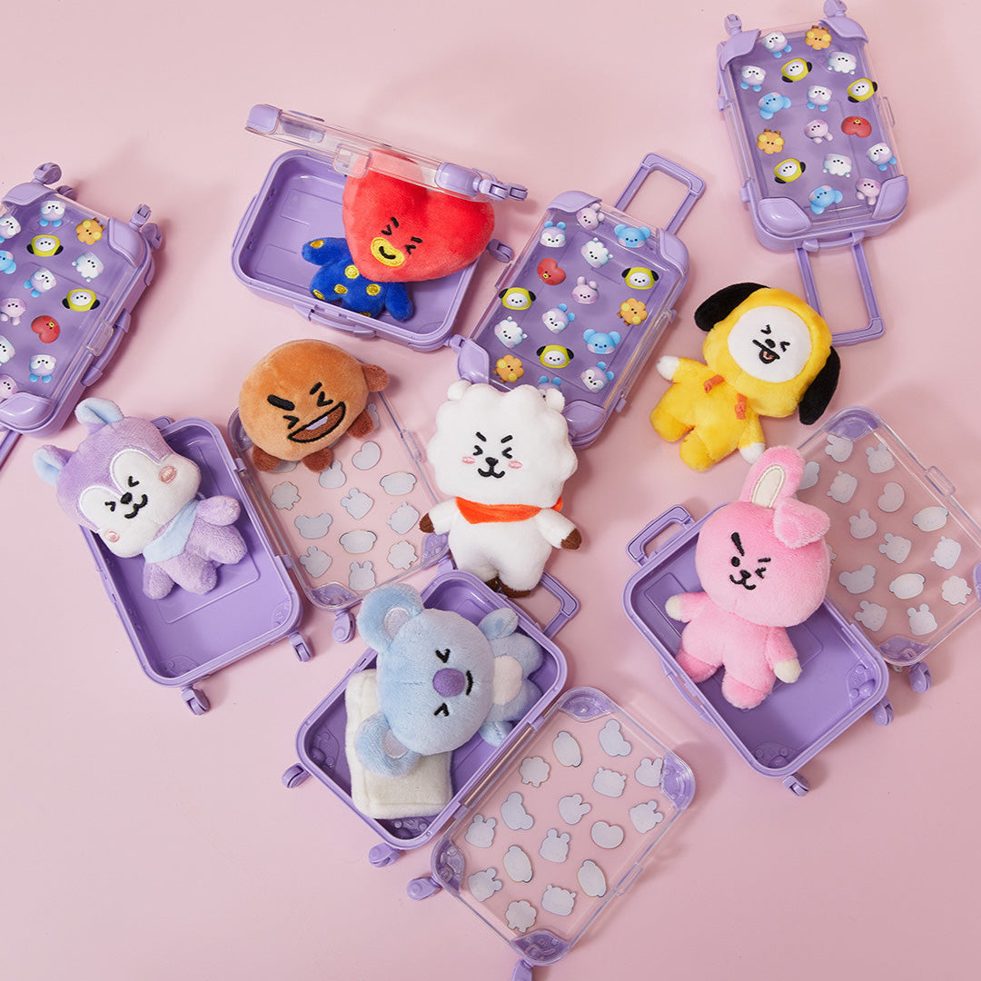 Overhead shot of plush toy characters in lavender toy suitcases.